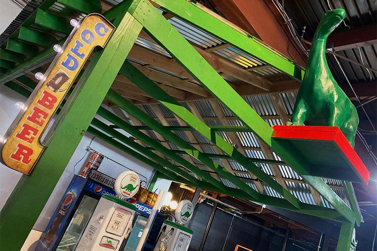 The interior of the Truck Bar that has green beams and a sign to the left that says "Cold Beer"
