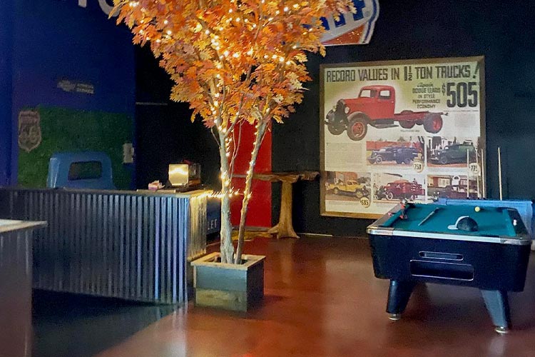 Interior image of the Truck Bar Higganum, pool table, and tree with lights.